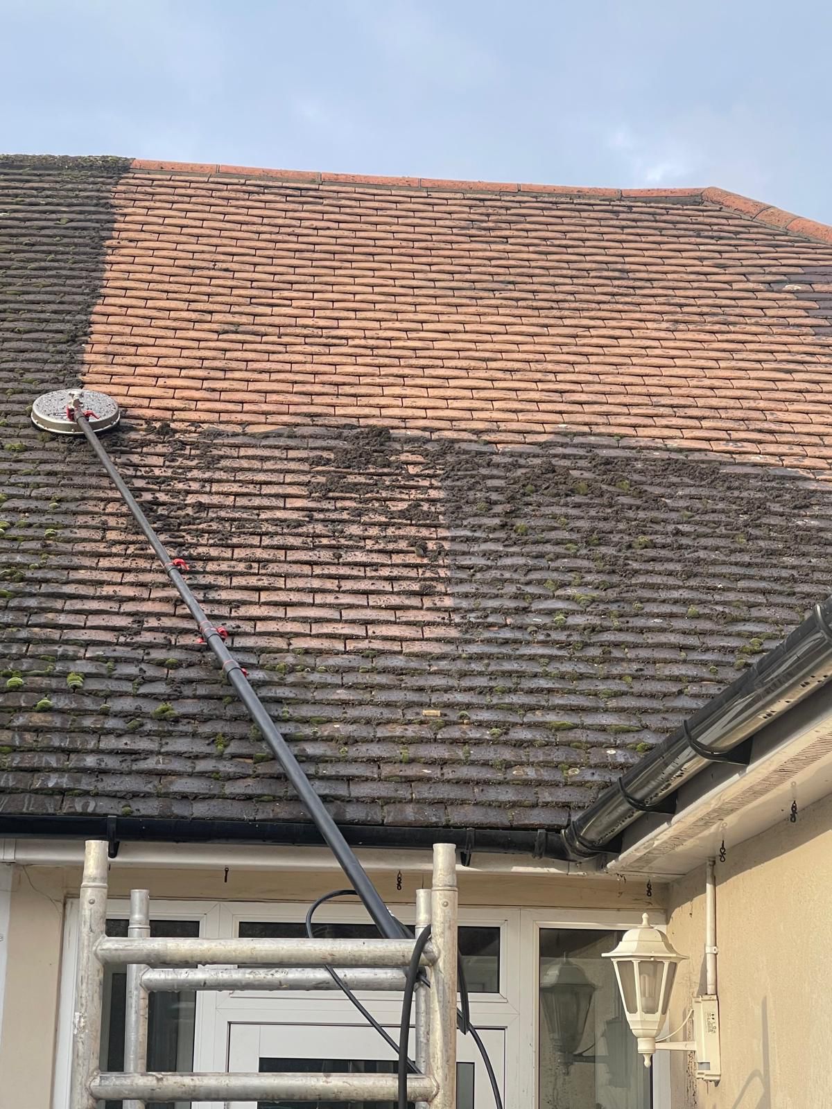 Professional roof cleaning in action — moss removal from roof tiles in London